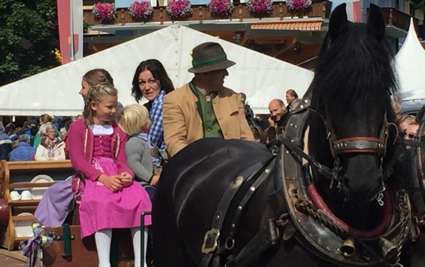 Mädchen in Tracht auf der Pferdekutsche